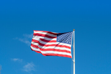 American flag - star and stripes floating over a blue sky