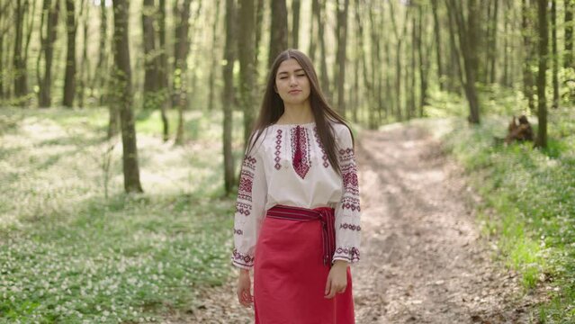 wide 4k shot of young beautiful Ukrainian woman in vyshyvanka  - ukrainian national clothes outdoor in the woods. Stand with Ukraine  