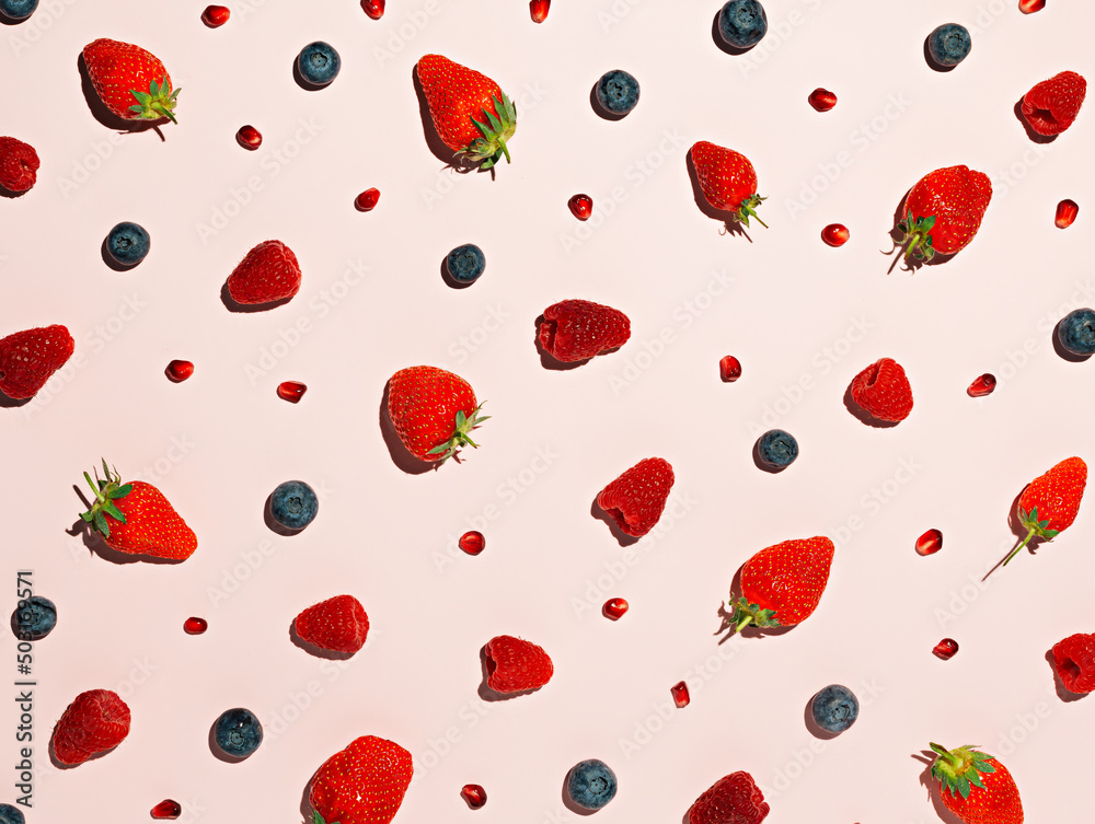 Wall mural colorful fruit pattern of wild berries on red background. creative summer fruit concept. strawberrie