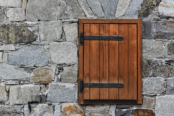 Stone wall with wooden shutter background.