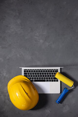 Computer laptop on cement floor. Laptop and construction tools