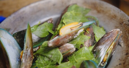 Close up fresh green mussels boiling steaming in hot pot with green Basil leaves, thai seafood	
