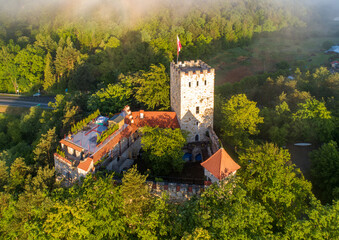 Medieval Tropsztyn castle in Lesser Poland by the Dunajec river with a landing platform for helicopters. Aerial view in sunrise light - 503175707