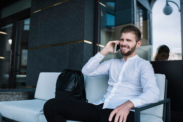 Cheerful businessman talking on phone in downtown