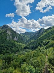 Fototapeta na wymiar Picturesque canyon of the Tara river.Mountains surrounding the canyon.Forests on the slopes of the mountains.Haze over the mountains. View from the Djurdzhevich Bridge Montenegro