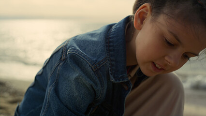 Happy kid playing beach at summer sea. Little girl enjoying vacation holiday.