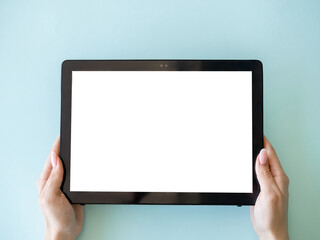 Digital mockup. Online education. Modern technology. Female hands holding tablet computer with blank screen isolated blue.
