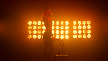 Girl erotically squat performing sexy dance near chair. Woman dancing sensually 