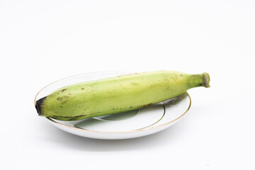 single banana with drop of water in a plate isolated on white