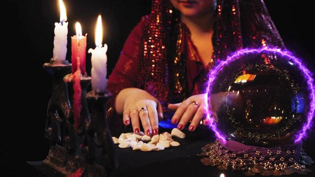 A fortune-teller in a magic salon works with runes by candlelight. Overall plan