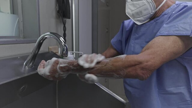 Surgeon man washing hands before operating. Medical themes