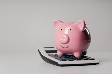 Pink piggy bank on a calculator. Finance, tax or investment concept