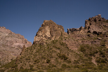 Fototapeta premium View of the arid desert and rocky mountains under a blue sky. 