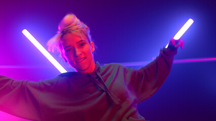 Hip hop dancer performing energetic dance in club ultraviolet lights close up. 