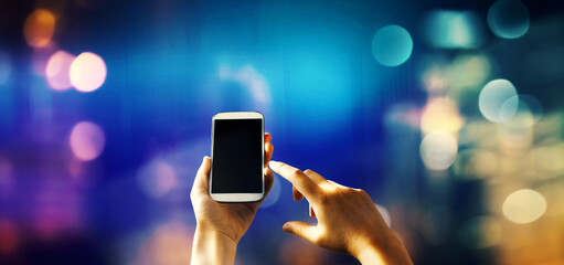 Person using a smartphone on blurred city background