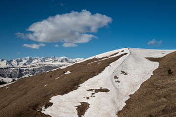 a snowy slope in the mountains and a beautiful cloud