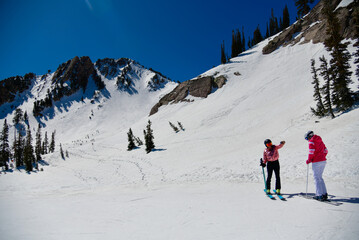 Fototapeta na wymiar Female skiers enjoy beautiful landscape at Snowbasin Ski Resort in Utah.