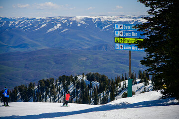 Ski vacation at Snowbasin Ski Resort in Utah in April. View from the peak to the slopes and valley...