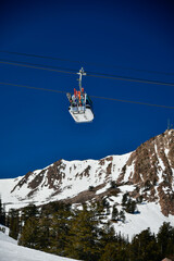 Gondola lift going up at the Snowbasin Ski Resort in Utah. Beautiful landscape of rocky mountains around.