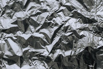 Background, texture of silver shiny foil, colored crumpled paper. Photo, top view, copy space.