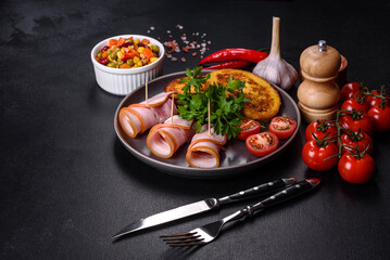 Slices of delicious raw or salted bacon with spices, salt, vegetables and herbs on a wooden cutting board