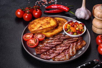 Slices of delicious grilled bacon with croutons fried in egg with spices, salt, vegetables and herbs