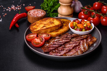 Slices of delicious grilled bacon with croutons fried in egg with spices, salt, vegetables and herbs