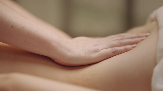 relax and pleasure in massage parlor in spa salon, closeup of masseuse hands on body of patient
