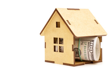 Roll of dollar bills inside a wooden house model
