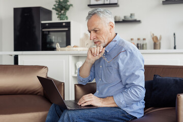 Fototapeta premium Senior man making video call on laptop computer