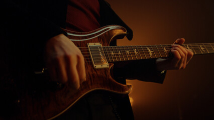 Unknown man hands playing guitar solo in club. Guy musician performing music.