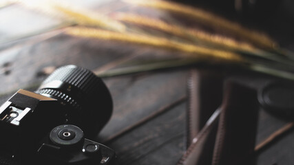 Fototapeta na wymiar Retro film camera and negative film on a black wooden table