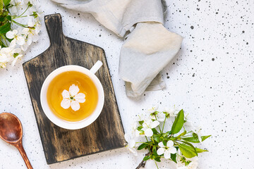 Artistic composition with aromatic herbal tea on the wooden tray decorated by beautiful spring...