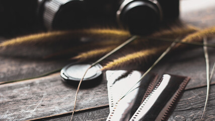 Retro film camera and negative film on a black wooden table
