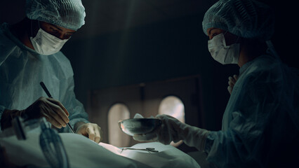 African american surgeon operating patient in sterile hospital emergency room.