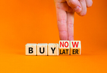 Buy later or now symbol. Businessman turns wooden cubes and changes concept words Buy later to Buy now. Beautiful orange table orange background. Business buy later or now concept. Copy space.