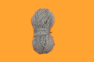 Grey skein of yarn on an orange background
