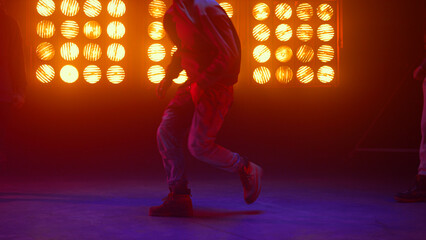 Breakdance guy showing dance elements in spotlight. Dancers performing hip-hop.
