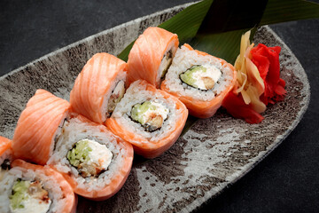 Roll Philadelphia with eel and salmon on a dark background