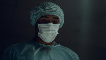 Portrait professional surgeon operating patient in hospital emergency room.