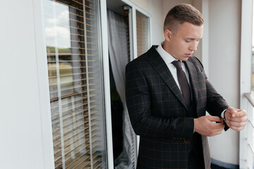 Businessman adjusting jacket on balcony