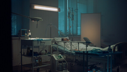 Patient lying with oxygen mask in hospital ward. Modern operating room interior.