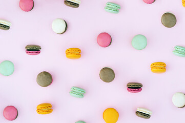 Colorful macarons on a pink background. Aesthetic sweet food wallpaper concept.