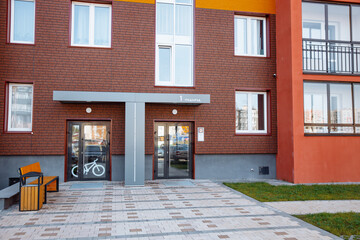 Entrance of a new modern residential apartment building with parking for bicycles and a bench. Concept of modern apartments