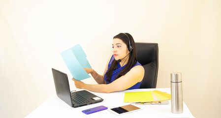 cute and beatiful successful CEO women, in blue blouse, working hard at laptop checking her documents, on white background