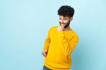 Young Moroccan man isolated on blue background celebrating a victory