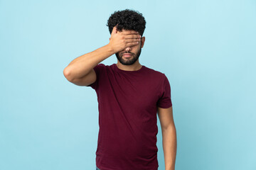 Young Moroccan man isolated on blue background covering eyes by hands. Do not want to see something