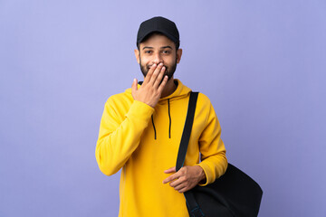Young sport Moroccan man with sport bag isolated on purple background happy and smiling covering mouth with hand