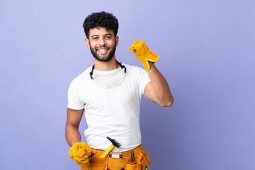 Young electrician Moroccan man isolated on purple background celebrating a victory