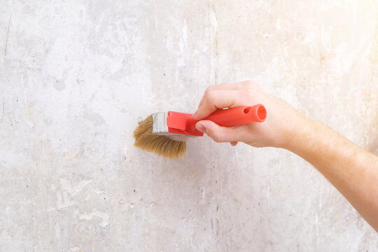 A man applies wallpaper glue with a brush for wallpapering. Repair of a room, apartment, house.
